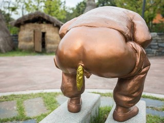 Срущий памятник с золотой какашкой.